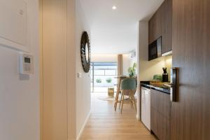 un pasillo que conduce a una cocina con un reloj en la pared en Marinha Grande apartamentos N5 ICE, en Marinha Grande