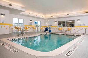 a large swimming pool in a building with yellow chairs at Fairfield Inn & Suites by Marriott Fredericksburg Texas in Fredericksburg