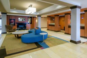 een lobby met een blauwe bank en een tafel en stoelen bij Fairfield Inn & Suites Kennett Square in Kennett Square