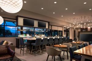 a restaurant with a bar with chairs and tables at Residence Inn by Marriott Boulder Canyon Boulevard in Boulder
