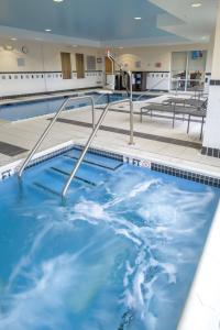 - une grande piscine d'eau bleue dans un bâtiment dans l'établissement Fairfield Inn & Suites Kennett Square, à Kennett Square