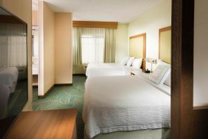 SpringHill Suites by Marriott Bentonville في بنتونفيل: غرفة فندقية بسريرين ونافذة