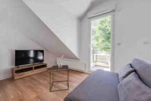 a living room with a couch and a tv at L’appart Lodge 106 in Sévrier