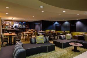 a restaurant with tables and chairs and a bar at Courtyard by Marriott Daytona Beach Speedway/Airport in Daytona Beach