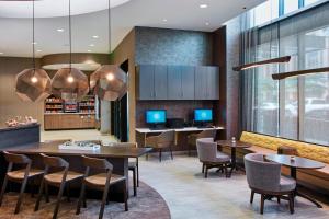 una sala da pranzo con tavoli e sedie in un edificio di SpringHill Suites by Marriott Milwaukee Downtown a Milwaukee