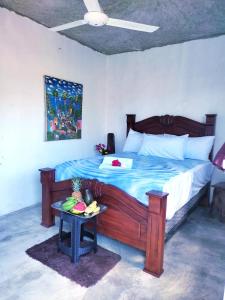 a bedroom with a large wooden bed with a table at Hotel i t a in Las Galeras