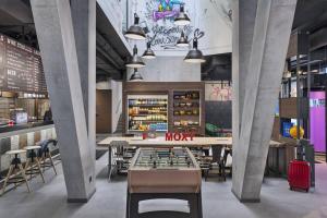 un restaurant avec des tables, des chaises et une table avec un échiquier dans l'établissement Moxy Lausanne City, à Lausanne