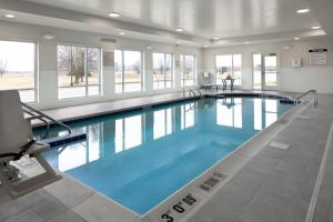 a large swimming pool with blue water in a building at TownePlace Suites by Marriott Oshkosh in Oshkosh