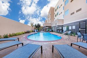 a pool at a hotel with tables and benches at Courtyard Houston I-10 West/Park Row in Houston