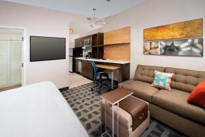 a small living room with a couch and a kitchen at TownePlace Suites by Marriott Alexandria Fort Belvoir in Woodlawn
