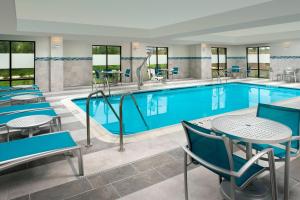 een zwembad met tafels en stoelen in een hotelkamer bij TownePlace Suites by Marriott Alexandria Fort Belvoir in Woodlawn