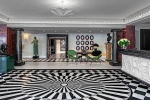 a lobby with a table and chairs in a building at Hôtel de Berri Champs-Élysées, a Luxury Collection Hotel in Paris