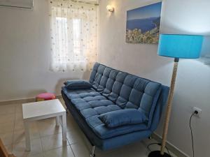 a blue couch in a living room with a lamp at Guesthouse Stivan (920) in Cres