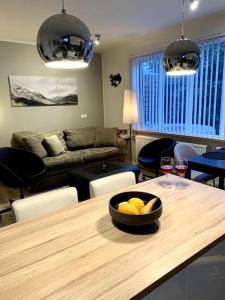 salon ze stołem z miską owoców i kieliszkami do wina w obiekcie Cosy one bedroom apartment in Reykjavík w Reykjavík