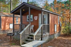 a cabin in the woods with a porch and stairs at Camp Cardinal in Broad Marsh