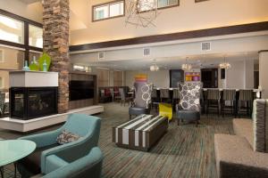 a lobby with a fireplace and chairs and a table at Residence Inn by Marriott Las Vegas Airport in Las Vegas