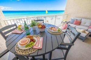 a table with food and fruit on a balcony with the beach at Beach House 301D - Southern Magnolia in Destin