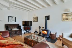 a living room with a couch and a wood stove at Finest Retreats - Middle Warble Stables in Mellor