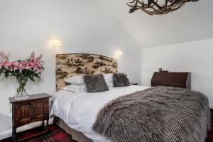 - une chambre avec un lit et un vase de fleurs dans l'établissement Finest Retreats - Middle Warble Stables, à Mellor