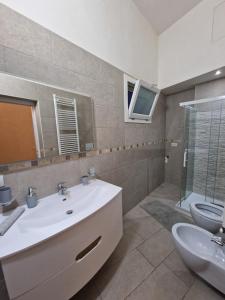 ein Badezimmer mit einem weißen Waschbecken und einem WC in der Unterkunft Casa Dolce Vita in Carovigno