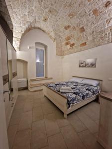 ein Schlafzimmer mit einem Bett und einer Steinmauer in der Unterkunft Casa Dolce Vita in Carovigno