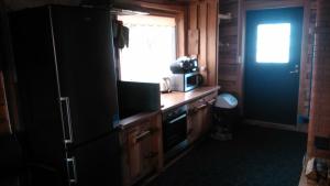 a kitchen with a refrigerator and a microwave at Udu Holiday House in Änkküla