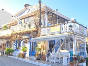 a building with white and blue trim and tables and chairs at Stella Apartments Malia in Malia