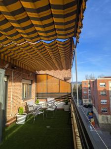 Un patio con sillas y una mesa en el balcón. en Ático La Real, en Nájera