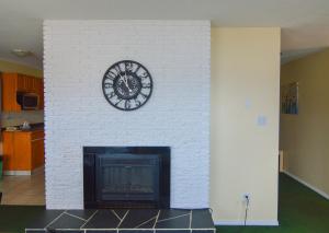 a white brick fireplace with a clock on it at Shoreline Resort Condominiums in Penticton