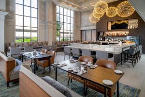 a restaurant with tables and chairs and a bar at Delta Hotels Huntington Downtown in Huntington