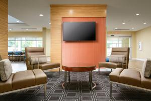 una sala de espera con TV de pantalla plana en la pared en TownePlace Suites by Marriott Tuscaloosa, en Tuscaloosa