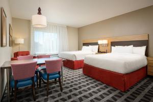 um quarto de hotel com duas camas e uma mesa e cadeiras em TownePlace Suites by Marriott Tuscaloosa em Tuscaloosa