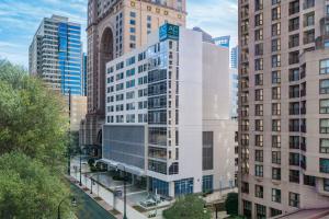 a tall white building in a city with tall buildings at AC Hotel by Marriott Atlanta Midtown in Atlanta