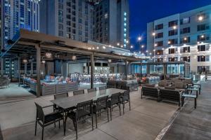 a rooftop patio with tables and chairs and buildings at AC Hotel by Marriott Atlanta Midtown in Atlanta