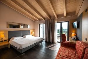 a bedroom with a bed and a large window at Villa Luisa Resort & Luxury Apartments in San Felice del Benaco