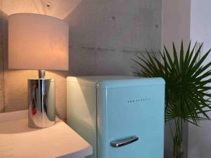 a blue refrigerator next to a lamp and a plant at Super cool & comfortable in the heart of Condesa. in Mexico City