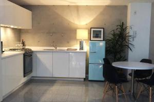 a kitchen with a blue refrigerator and a table at Super cool & comfortable in the heart of Condesa. in Mexico City