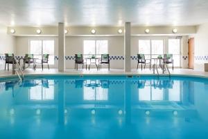 a pool in a room with chairs and tables at Fairfield Inn & Suites Minneapolis Eden Prairie in Eden Prairie