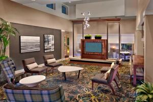 een lobby met stoelen en een flatscreen-tv bij Residence Inn Orlando Lake Mary in Lake Mary