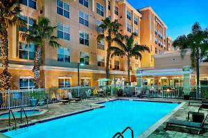einen Pool vor einem Hotel mit Palmen in der Unterkunft Residence Inn Orlando Lake Mary in Lake Mary
