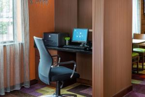 a computer sitting on a desk with a chair at Fairfield Inn & Suites Springfield in Springfield +16 photos