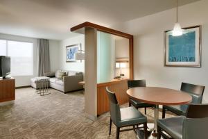 une chambre d'hôtel avec une table et un salon dans l'établissement SpringHill Suites by Marriott Rexburg, à Rexburg