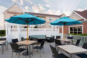 un patio con mesas y sillas y sombrillas azules en Residence Inn by Marriott Amarillo, en Amarillo