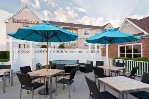 a patio with tables and chairs with blue umbrellas at Residence Inn by Marriott Amarillo in Amarillo