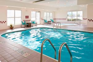 a swimming pool in a hotel room with blue chairs at Residence Inn by Marriott Amarillo in Amarillo