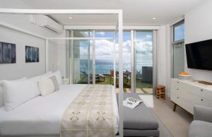 a bedroom with a bed and a view of the ocean at Azura Bermuda in Bermuda