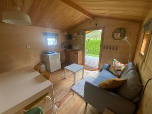 a living room with a couch and a table at Blokhut 4-persoons De Blauwe Lantaarn in Wateren +4 photos