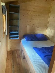a bedroom with a bed in a wooden cabin at Blokhut 4-persoons De Blauwe Lantaarn in Wateren