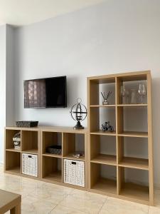 a wooden book shelf with a tv on a wall at Lemos Estrella in Monforte de Lemos