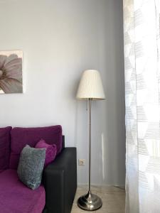 a living room with a purple couch and a lamp at Lemos Estrella in Monforte de Lemos